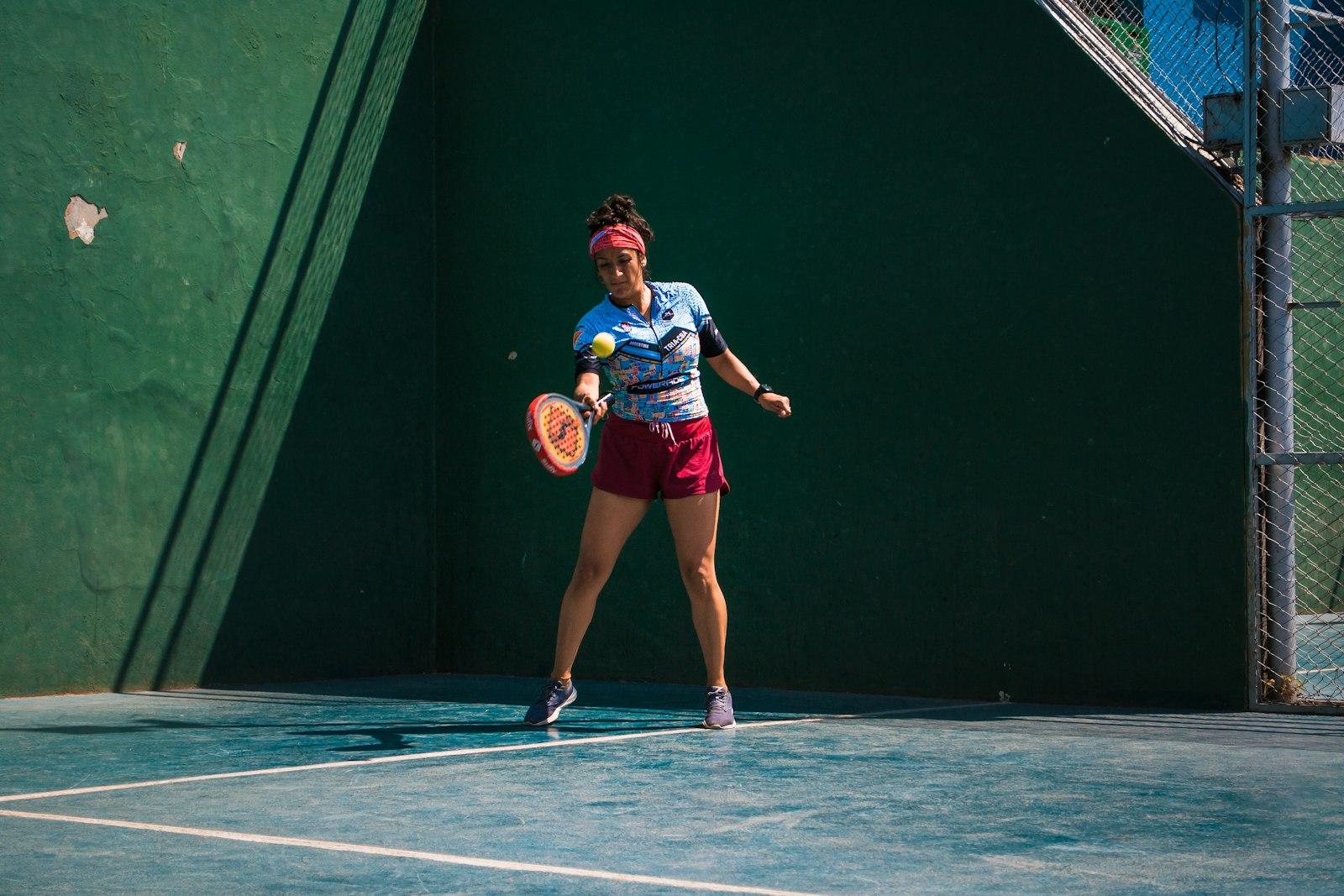 A woman playing a forehand on a padel court